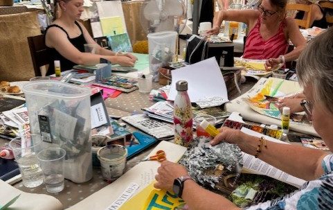 Phiona Hutton Counsellor and Integrative therapist, in person Havant, Hampshire or online nationwide. A group of people engaged in creative activities at a cluttered table.
